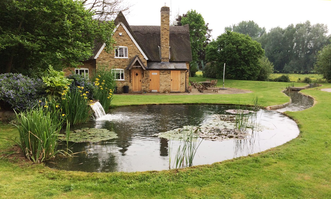 Large wildlife pond with waterfall in a country garden