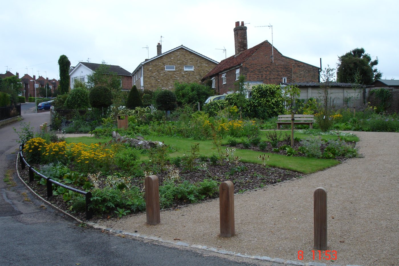 Community green space with planted beds and gravel pathway