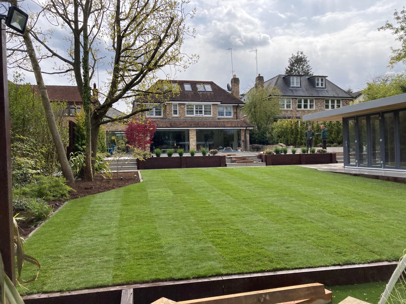 Manicured striped lawn in a large family garden with patio