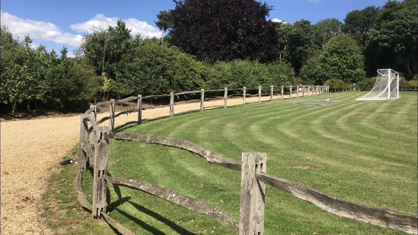 Playing field with post and rail fencing and goal