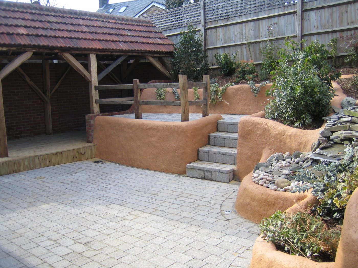 Rendered raised beds, rockery water feature and oak framed structure